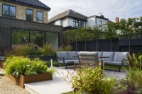 Rear garden with seating area and raised corten steel beds. 