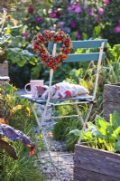 Heart shaped wreath on seat made of rosehips, beechnuts and acorns.
