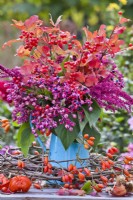 Bouquet of autumn foliage and berries containing Clerodendrum trichotomum and Viburnum opulus - Guelder rose.