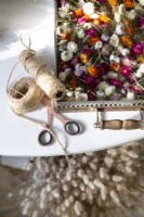 Reels of twine, scissors and dried flowers