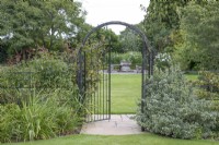 View through the gate to the circular seating area at The Burrows Gardens, Derbyshire, in August
