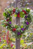 Heart shaped autumnal wreath made from common juniuper, poppy seedheads and Callicarpa and rowan berries.