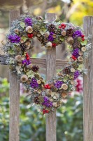 Heart shaped wreath made from cones, poppy seedheads, rowan and Callicarpa berries, lichens and acorns.