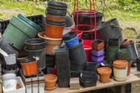 Gardener's potting table with assorted containers in backyard garden in summer