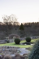 The Jewson Terrace at Cotswold Farm Gardens in February with geometric beds and clipped evergreens including yew and box..