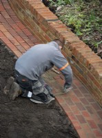 A worker pointing the bricks on a newly built  path during the makeover of a London garden.