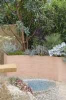 Drought tolerant garden with stone water feature and curved terracotta planters with Arbutus, Salvia, Rosmarinus officinalis 'Prostratus' and Senecio candidans 'Angels Wings' - A Mediterranean Reflection, RHS Chelsea Flower Show 2022 - Silver Medal