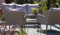 Rattan garden furniture with cushions and a low table - The Chic Garden Getaway - BBC Gardeners' World Live 2023 - Designer: Katerina Kantalis