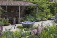 A sunken covered dining area overlooks a seasonal potager filled with ornamental and edible plants, combined in formal or informal schemes, in borders or raised beds.