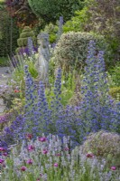 View of mixed perennials and shrubs border in an informal country cottage garden in Summer - June