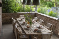 A sunken dining area overlooks a seasonal potager filled with edible and ornamental plants.