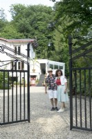 Owners of Villa Sprezzatura welcoming near the black iron gate.