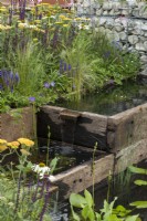 A wildlife friendly, sustainable city space with reclaimed timber pools, edged in grasses and perennials.