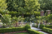 A formal courtyard garden inspired by Charleston, South Carolina, combines palms and exotics with shrub roses, hydrangeas and perennials.