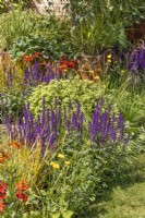 View across small bed to square planter, summer July