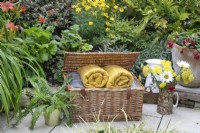 Harrods basket full of blankets in small suburban garden in Lichfield, Staffordshire, in red orange and yellow theme, July