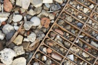 Detail of garden path using stones and rusty metal grid. Summer.