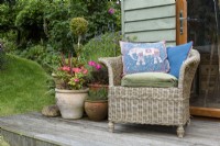 Rattan chair with an Indian cushion in a garden in July