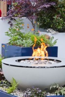 Circular firepit in contemporary garden.