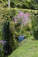 Lush planting below the rampart of an iron age hill fort in a Dorset garden in August