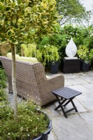 Rattan seat and table on a terrace in a September garden