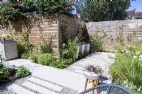 Mixed planting Border around garden edges with staggered stone tile path running in between