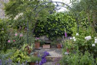 Garden arch flanked to the left by Rosa Bonica and to the right by Rosa 'Desdemona'.
