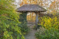 View through a covered lych gate garden entrance in Autumn - November