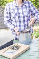 Woman mixing grit and compost in metal bucket