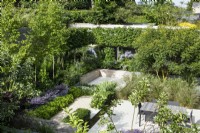 Overview of modern garden with sunken seating area and dining table