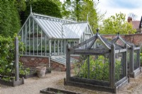 A formal kitchen garden with bespoke oak cloches to protect vulnerable crops, and an Alitex greenhouse.