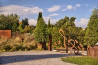 Mediterranean  entrance gates decorated  with musician instruments elements - violines and treble clef and grassland on the background in autumn time, sunlit with warm evening light.

Italy, Tuscan Maremma, Orbetello
Autumn season, October

