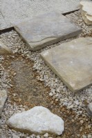 Stepping stone slabs laid on gravel for easy drainage.