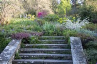 Wide, stone steps lead towards a mixed border at Gravetye Manor.