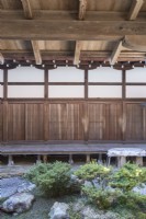 Part of small courtyard garden within temple complex with view to internal covered wooden walkways. 