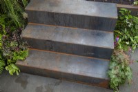 Metal steps in contemporary garden using recycled materials and a dark colour palette - the Hairy Gardener's Garden at BBC Gardener's World Live 2017, June