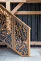 Ornate staircase made from corten steel in an oak frame building with stone paving 