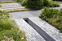 Clay brick pavers with a drainage channel and stone paving with mixed perennial borders planting