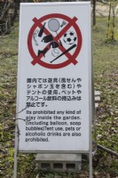 Sign in the garden in English and Japanese prohibiting several activities