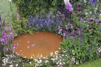 Corten steel circular small pond in 'RHS Garden for Wildlife Wild Woven' - RHS Chatsworth Flower Show 2019, June