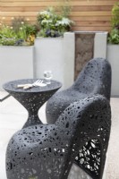 Contemporary black plastic seats in 'Tending the Mind' garden at RHS Chatsworth Flower Show 2019, June