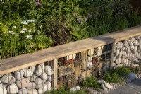 A gabion frame insect hotel with a reclaimed timber bench