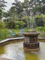 Urn shaped fountain and octagonal water feature in a garden