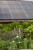 Solar panels on the garage roof in summer garden