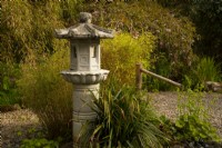 A stone carved Japanese lantern and Japanese bamboo water fountain in the Japanese garden.