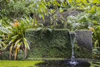One of many water features, a rill drops water from one square water tank to another, surrounded by tropical foliage. Monte Palace Gardens, Madeira