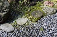 Stone stepping stones next to surface of granite pebbles. 