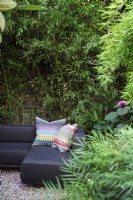 Corner sofa in secluded area of garden with bamboo