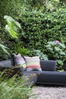 Cushions on corner sofa in secluded area of garden