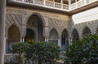 The Patio de las Doncellas, Maidens Courtyard, with poly lobed arches and architecture in the Mudejar style with standard fruit trees. Real Alcazar Palace gardens, Seville. Spain. September. 